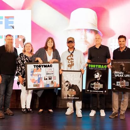 Group celebrating music industry awards onstage